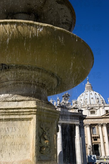 ITALY, Lazio, Rome, Vatican City The Basilica of St Peter and the square or Piazza San Pietro with tourists and a water fountain in the foreground