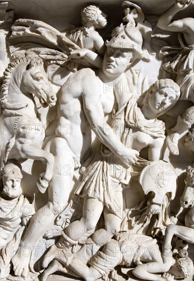 ITALY, Lazio, Rome, Vatican City Museums Detail of a marble sarcophagus in the Octagonal Courtyard of the Belvedere Palace depicting a battle scene with one soldier helping another injured soldier