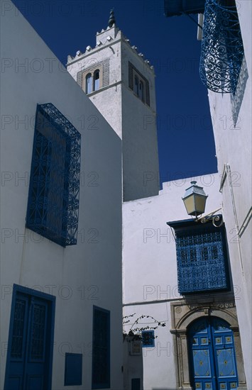 TUNISIA, Sidi Bou Said, "Part view of white painted mosque with decorative, blue painted balconies, window shutters and doorway."