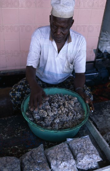 OMAN, Salalah, Trader sorting second grade frankincense.