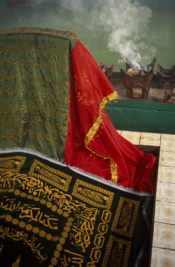 OMAN, Dhofar hills, Beit Zarbij, Frankincense burning in tomb of the prophet Job. Near Salalah.