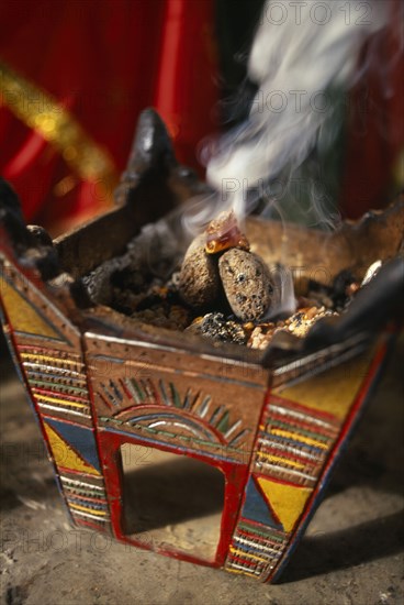 OMAN, Dhofar Hills, Beit Zarbij, Frankincense burning in tomb of the prophet Job. Near Salalah.