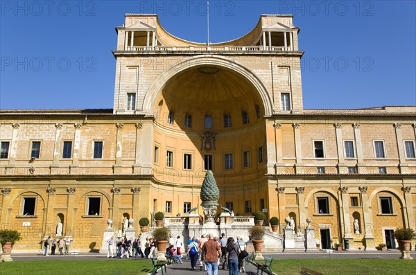 ITALY, Lazio, Rome, Vatican City Museum The central niche designed by Pirro Ligorio in the Belvedere palace housing the Cortile della Pigna a giant bronze pine cone from an ancient Roman fountain with tourists walking in the courtyard