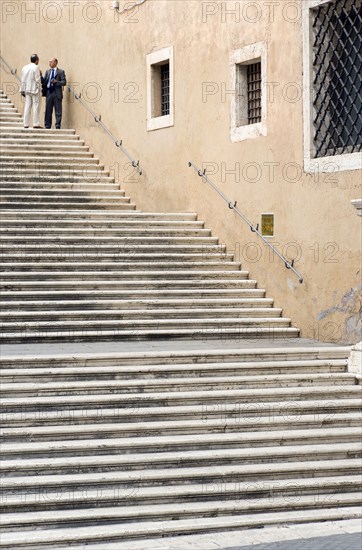 ITALY, Lazio, Rome, Two men talking in conversation on steps beside the Palazzo dei Conservatori on the Capitol