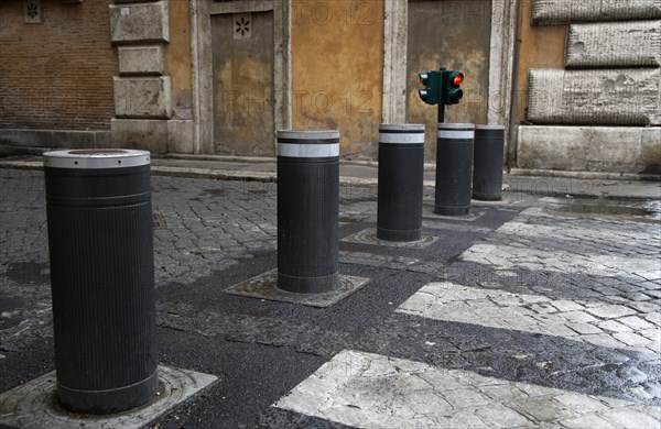 ITALY, Lazio, Rome, Automatic rising bollards and a pedestrian crossing in a side street with red and green traffic control lights
