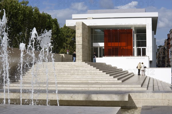 ITALY, Lazio, Rome, The fountain and steps with sightseers leading to the building hosuing the Ara Pacis or Altar of Peace built by Emperor Augustus to celebrate peace in the Mediteranean. The red prespex cube is part of a Valentino fashion exhibition at the museum