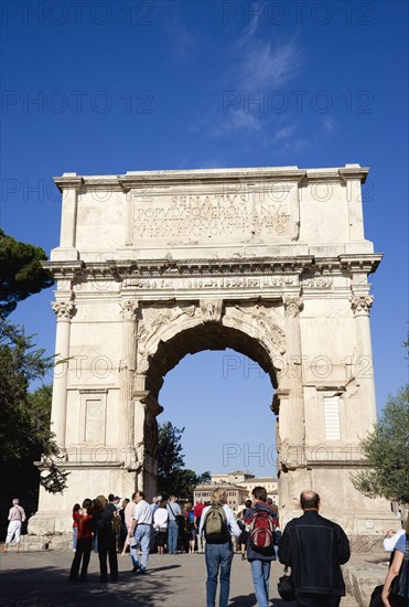 ITALY, Lazio, Rome, Tourists around the 19th Century reconstruction of the triumphal Arch of Titus in the Forum