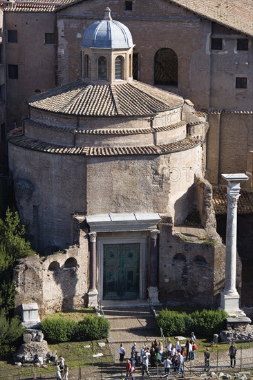 ITALY, Lazio, Rome, Tourists in the Forum outside the 4th Century Temple of Romulus which survived as part of the attached church of Santi Cosma e Damiano