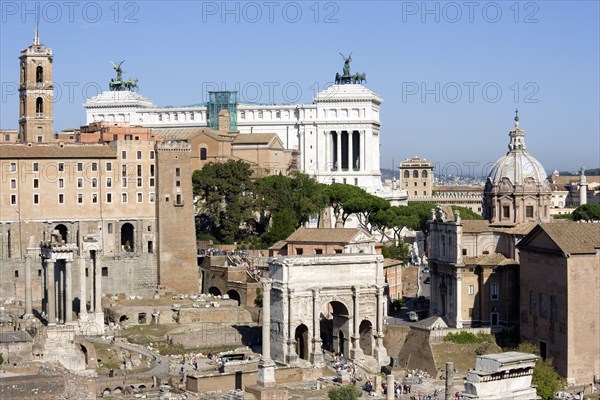ITALY, Lazio, Rome, "The Forum and tourists with from left to right the columns of the Temple of Saturn, the triumphal Arch of Septimius Severus, the Medieval church of Santi Luca e Martina and the Curia with the white marble Victor Emmanuel Monument beyond"