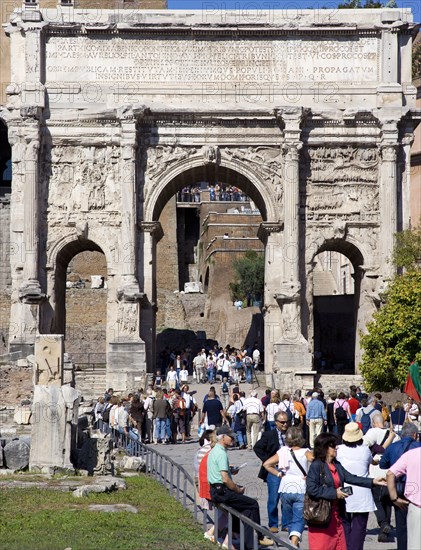 ITALY, Lazio, Rome, Tourists walking through the triumphal Arch of Septimius Severus from the Forum towards the Capitol