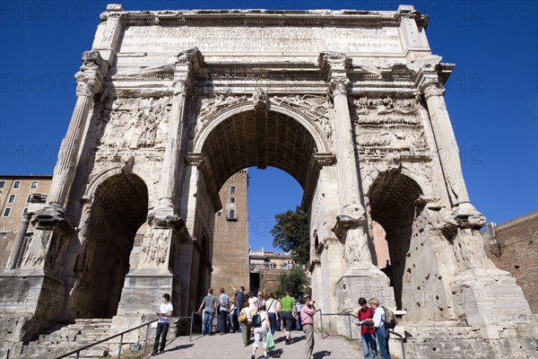 ITALY, Lazio, Rome, Tourists walking through the triumphal Arch of Septimius Severus from the Forum towards the Capitol