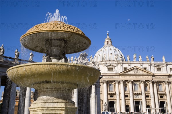 ITALY, Lazio, Rome, Vatican City The facade of the Basilica of St Peter with a water fountain and the colonnade by Bernini in the foreground