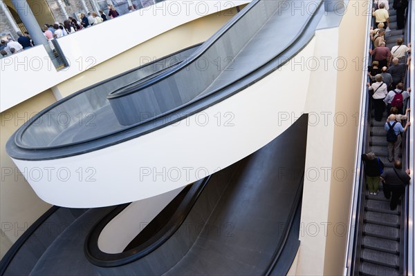 ITALY, Lazio, Rome, Vatican City Spiral ramp and escalator moving up with visitors at the entrance to the Museum