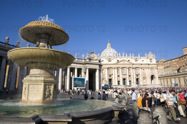 ITALY, Lazio, Rome, Vatican City Tourists in St Peter's Square for the wednesday Papal Audience in front of the Basilica with a water fountain in the foreground