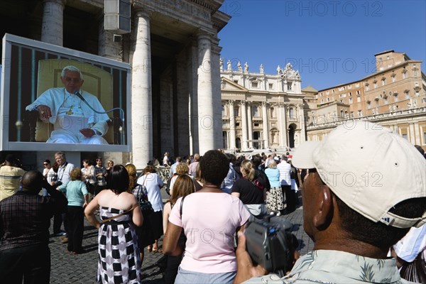 ITALY, Lazio, Rome, Vatican City Pilgrims in St Peter's Square for the wednesday Papal Audience in front of the Basilica watching Pope Benedict XVI Joseph Alois Radzinger on a large video TV monitor display