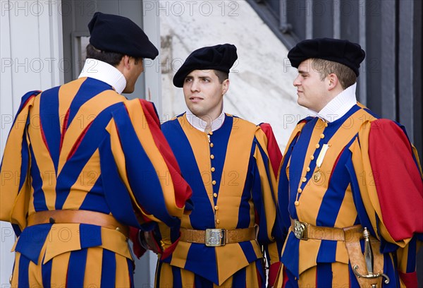 ITALY, Lazio, Rome, Vatican City Three Swiss Guards in full ceremonial uniform dress in conversation