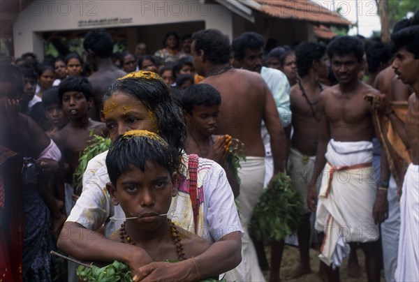 SRI LANKA, Religion, Hinduism, "Punnaccolai Festival. Tamil Oracle named Sothimalar with her arms wrapped around her son, both with ritual trident piercings inserted through cheeks"