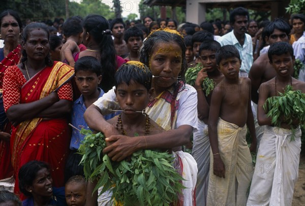SRI LANKA, Religion, Hinduism, "Punnaccolai Festival. Tamil Oracle named Sothimalar with her arms wrapped around her son, both with ritual trident piercings inserted through cheeks"