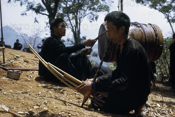 LAOS, Tribal People, Meo Tribe, Meo men playing musical instruments during the traditional ox killing ritual