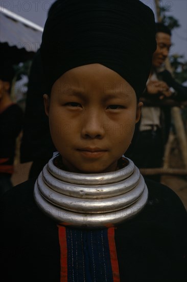 LAOS, Tribal People, Meo Tribe, Head and shoulders portrait of a Meo girl wearing traditional dress and neck rings.