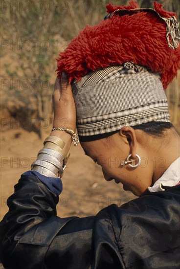 LAOS, Tribal People, Meo Tribe, Young Meo bride wearing jewellery and an elaborate red head-dress in preparation for her wedding