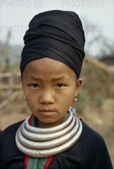 LAOS, Tribal People, Meo Tribe, Head and shoulders portrait of a Meo girl wearing traditional dress and silver bars around her neck which are used as money
