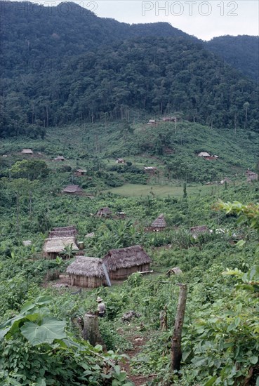 GUATEMALA, Alta Verapaz, Semuy, "Q’eqchi Indian refugee village. Thatched roof homes set amongst lush green plants, vegetation and rainforest."