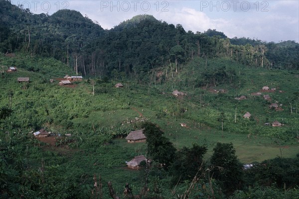 GUATEMALA, Alta Verapaz, Semuy, Q’eqchi Indian refugee village. Thatched roof homes set amongst lush green vegetation and rainforest.