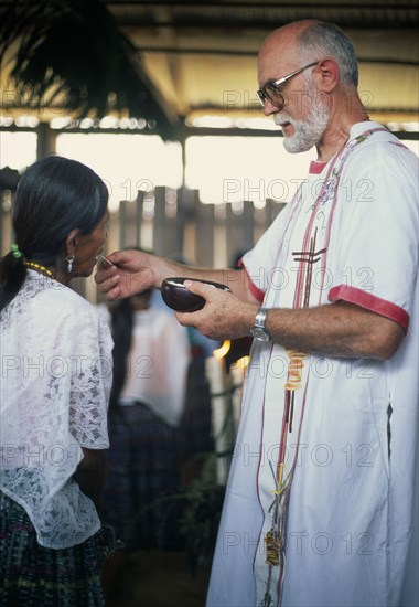 GUATEMALA, Alta Verapaz, Religion, Padre Tiziano an Italian Roman Catholic missionary giving communion to a Q’eqchi Indian woman