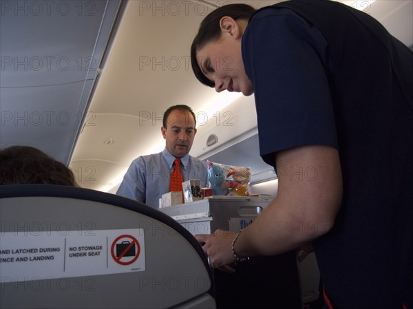 TRANSPORT, Air, Inflight, Cabin crew dispensing drinks and snacks during flight.