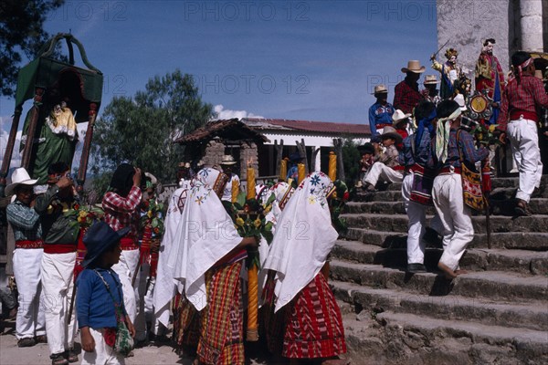 GUATEMALA, El Quiche, San Andres de Sajcabaja, Quiche Indians carrying a statue of the Patron Saint in procession up the church steps during San Andres Festival on December  8th