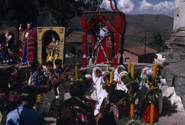 GUATEMALA, El Quiche, San Andres de Sajcabaja, Quiche Indians knelling in prayer to the saints outside the 16th century church during San Andres Festival on December 8th