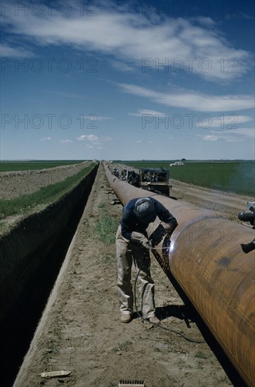 CANADA, Saskatchewan , Prairies, Constructing Trans Canada gas pipeline over Saskatchewan Prairies. A worker called Mr E Thompson welding