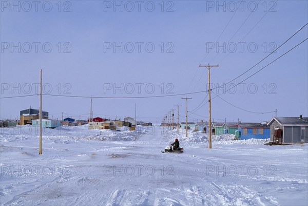 CANADA, Quebec, Hudson Bay, The Great Whale Settlement. Cree indigenous community. Housing and roads in heavy snow cover with a skidoo travelling past.