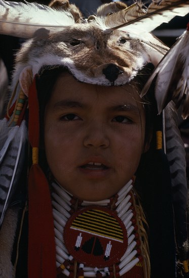 CANADA, Alberta, Edmonton, Blackfoot Native American Tribe. Portrait of a young participant at Pow Wow wearing tribal dress including a wolf and eagle feather head-dress