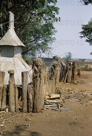 VIETNAM, Central Highlands, Plei Mrong , Montagnard village graveyard with carved wooden effigies of the dead in a squatting position with their hands over their faces