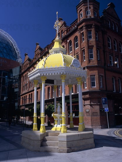 IRELAND, North, Belfast, "Victoria Square.  Yellow and white canopied Jaffe Fountain, constructed in 1874 as memorial to Daniel Joseph Jaffe in front of brick exterior facade of Bittles Bar."