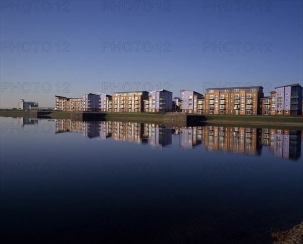 WALES, Carmarthenshire , Llanelli, Millennium Quay dockside apartments development with the buildings reflected on water.