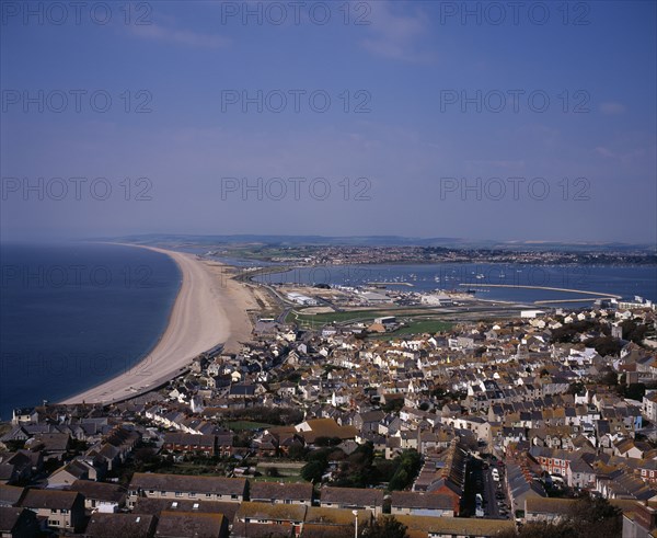 ENGLAND, Dorset, Portland, Elevated view over Chesil Beach from cliff path above town of Fortuneswell on Isle of Portland. Portland Harbour seen on the right.