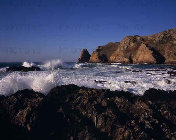 UNITED KINGDOM, Channel Islands, Jersey, St Ouen. Le Pulec. Rough sea and waves crashing against rocky foreshore