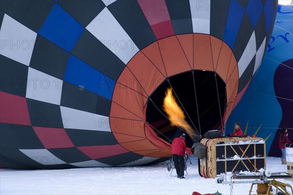 SWITZERLAND, Canton de Vaud, Chateau d'Oex, Flame being directed into inflated Hot Air Balloon to heat air inside.