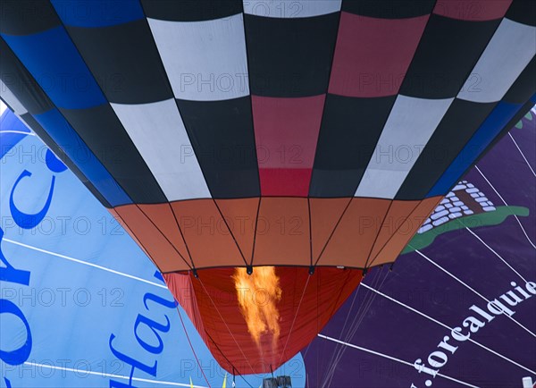 SWITZERLAND, Canton de Vaud, Chateau d'Oex, Close up of flame entering Hot Air Balloon to heat the air inside.
