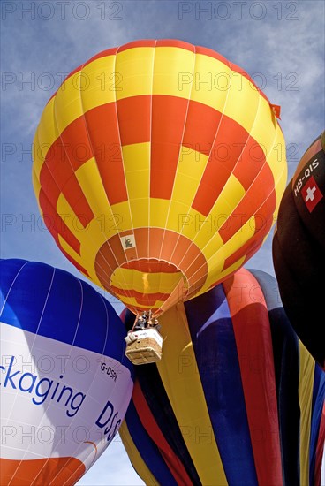 SWITZERLAND, Canton de Vaud, Chateau d'Oex, Hot Air Balloon taking off with people in basket visible.