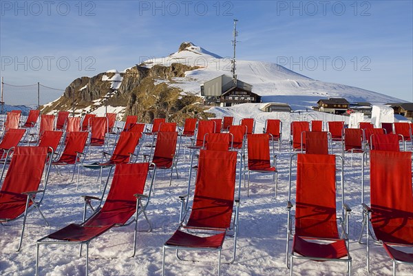 SWITZERLAND, Bernese Oberland, Mannlichen, Deckchairs on Mannlichen Mountain with cable car station at rear