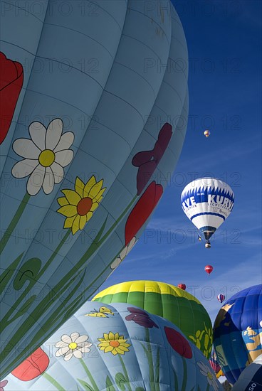 SWITZERLAND, Canton de Vaud, Chateau d'Oex, Hot Air Balloons taking off and framed by sections of other balloons.