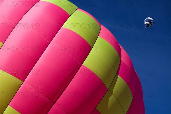 SWITZERLAND, Canton de Vaud, Chateau d'Oex, Section of Hot Air Balloon on ground as another balloon ascends