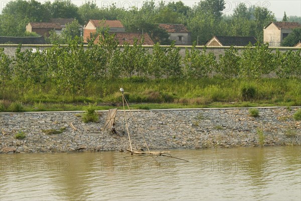 CHINA, Hubei, Yangtze, A man fishing on the lower embankment. Two lined embankments protect this village east of Wuhan from annual flooding of the Yangtze River