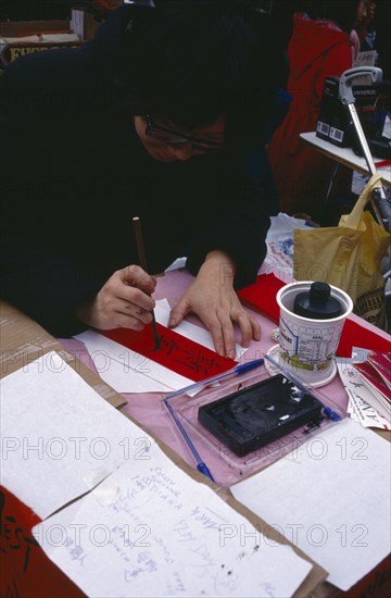 ENGLAND, London, Chinese New Year, Calligraphist writing Western names in Chinese during New Year celebrations in Chinatown.