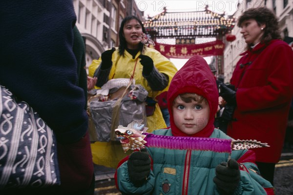 ENGLAND, London, Chinese New Year, "Young non-Chinese child holding paper lion during Chinese New Year celebrations in Chinatown, Soho. "