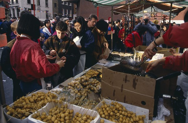 ENGLAND, London, Chinese New Year, "Food stall during Chinese New Year celebrations in Chinatown, Soho.  Diverse, racially mixed crowd."